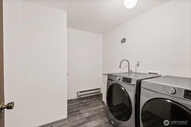 laundry area featuring a baseboard heating unit, dark wood-style flooring, washing machine and dryer, and cabinet space