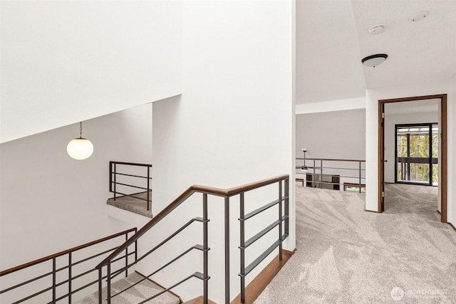 hallway featuring carpet flooring and an upstairs landing