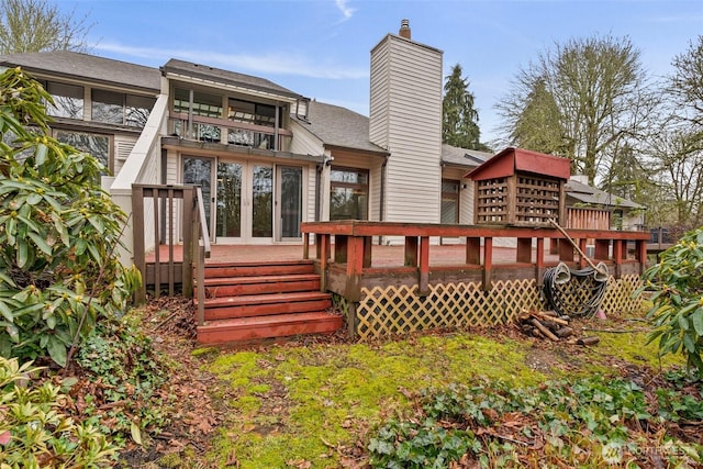 back of property with a chimney, a deck, and french doors