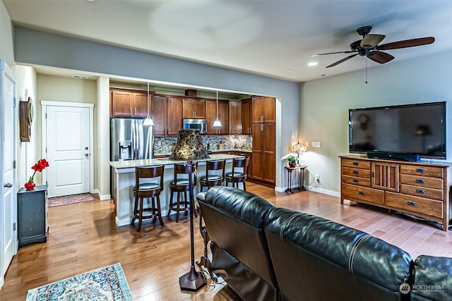 living room with light wood-type flooring and ceiling fan