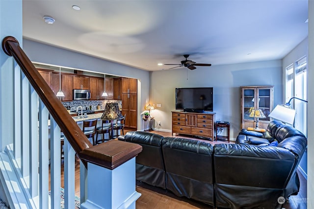 living room with wood-type flooring, ceiling fan, and sink