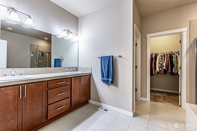 bathroom featuring tile patterned flooring, vanity, and an enclosed shower