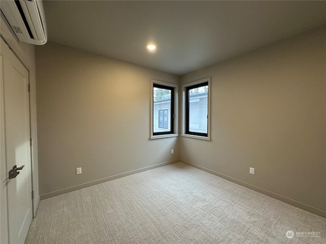 empty room featuring light colored carpet and a wall mounted air conditioner