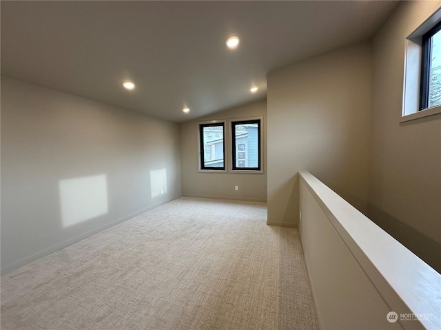 carpeted spare room with lofted ceiling