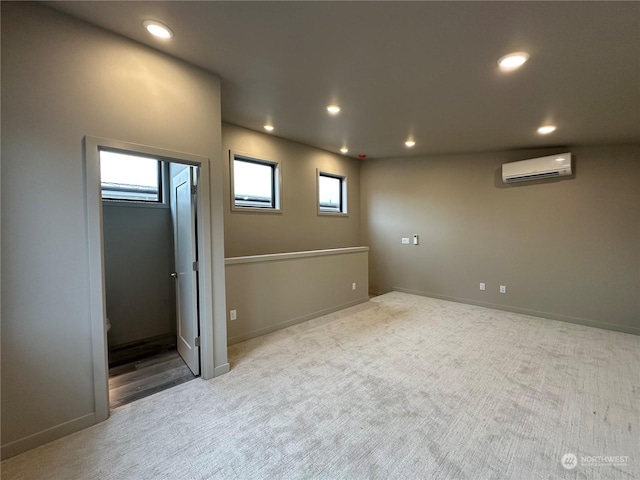 basement with a wall mounted AC and light colored carpet