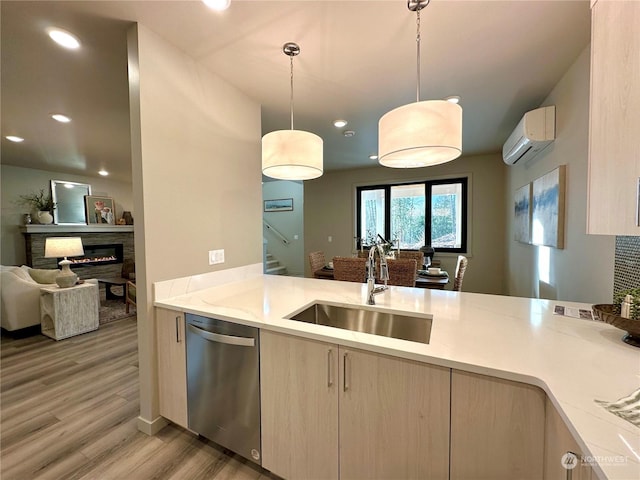 kitchen with sink, hanging light fixtures, light brown cabinets, stainless steel dishwasher, and a wall unit AC