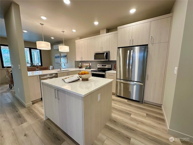 kitchen with sink, appliances with stainless steel finishes, hanging light fixtures, a kitchen island, and kitchen peninsula