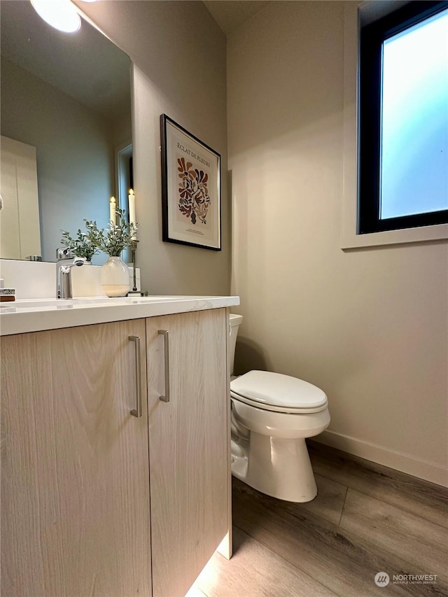 bathroom with vanity, toilet, and hardwood / wood-style floors