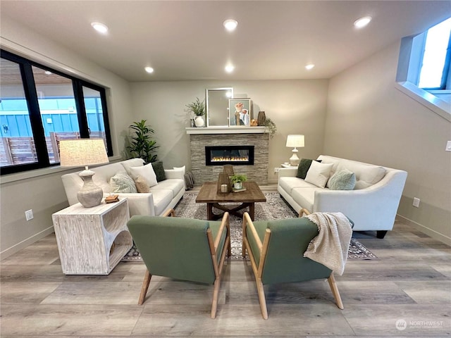 living room with light wood-type flooring and a fireplace