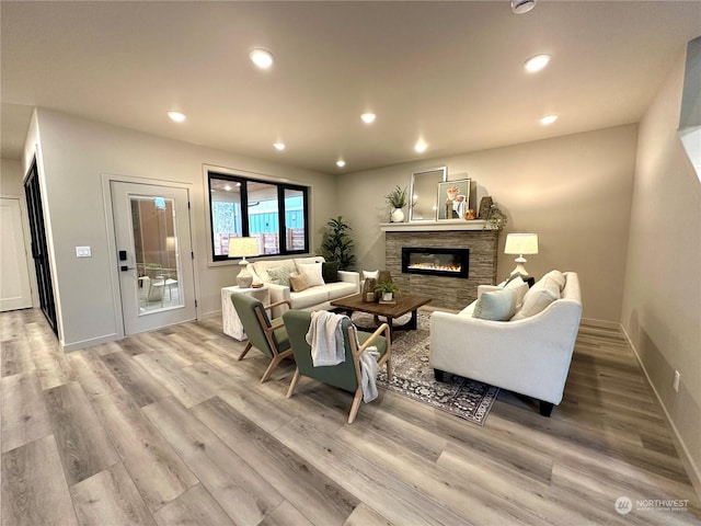 living room featuring a stone fireplace and light hardwood / wood-style floors