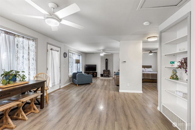 1989 NE Lisa Ln, Poulsbo, WA 98370 - living area featuring ceiling fan, baseboards, a wood stove, and light wood-style floors