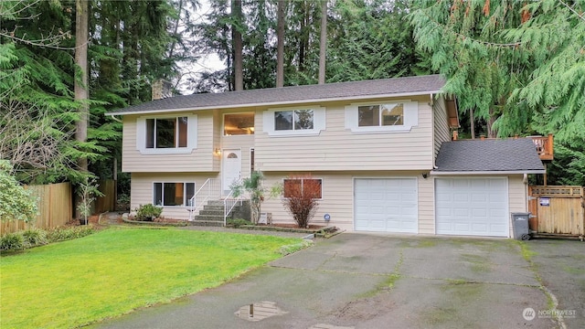 bi-level home with a garage and a front lawn