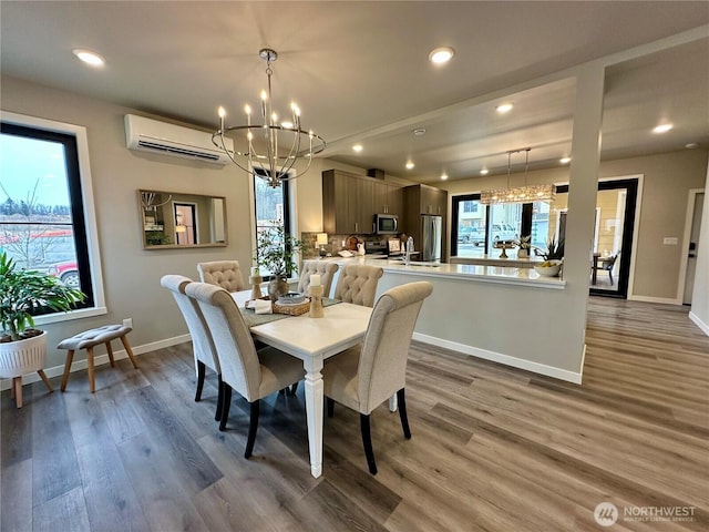 dining area with an inviting chandelier, dark hardwood / wood-style flooring, a wealth of natural light, and an AC wall unit