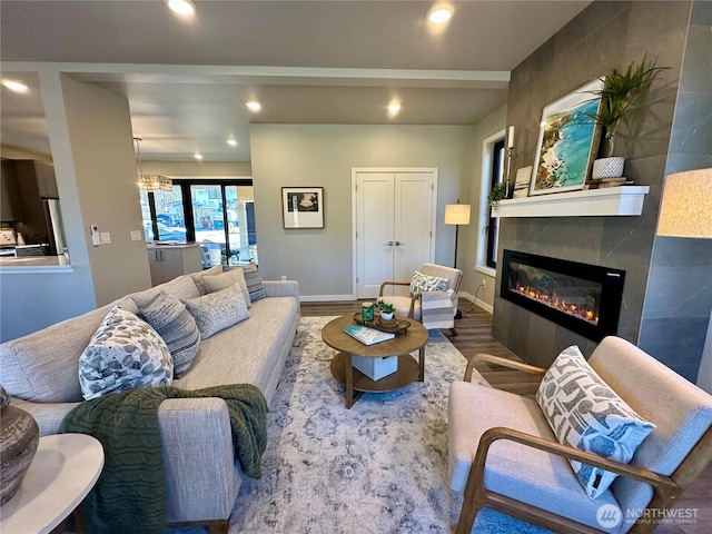 living room featuring wood-type flooring and a tile fireplace