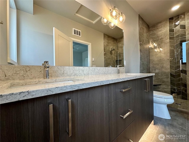 bathroom featuring a shower with door, vanity, tile patterned flooring, and toilet