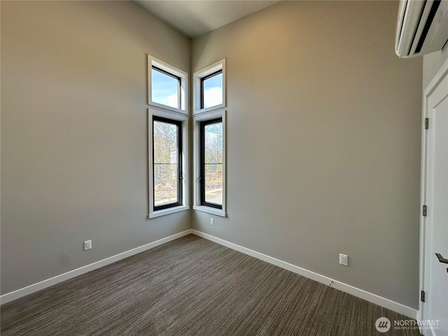 spare room featuring a wall mounted air conditioner and dark carpet