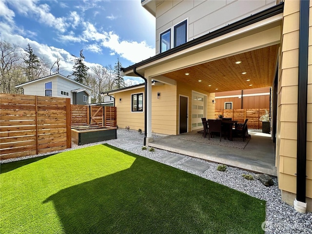 view of yard with a garage, a patio area, and fence
