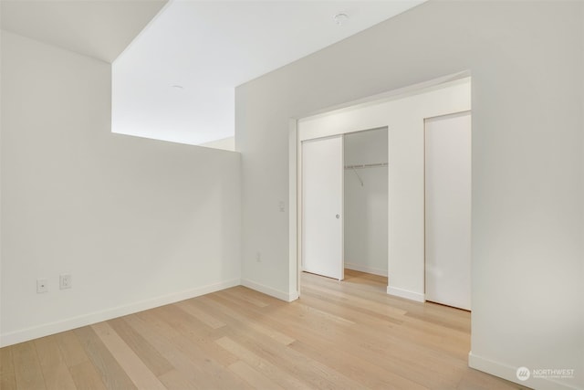 unfurnished bedroom with a closet and light hardwood / wood-style flooring