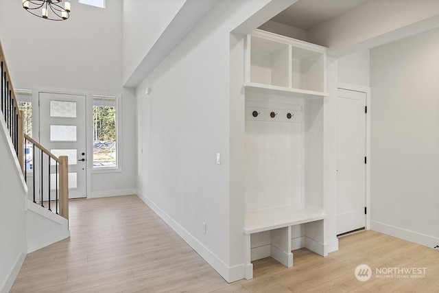 mudroom with light wood-type flooring and an inviting chandelier