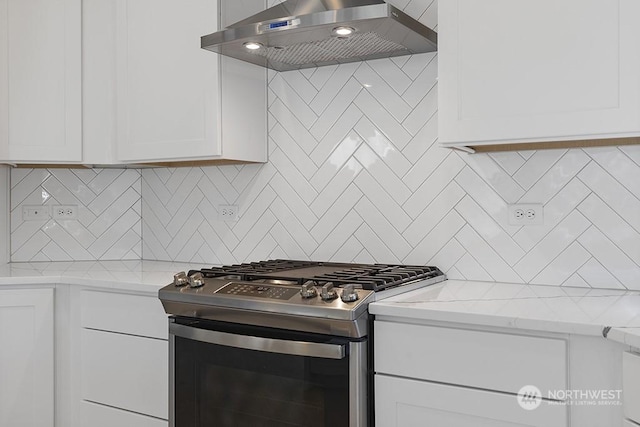 kitchen with white cabinets, wall chimney exhaust hood, gas stove, and tasteful backsplash