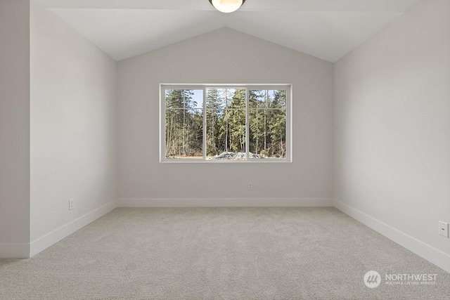 carpeted spare room with vaulted ceiling