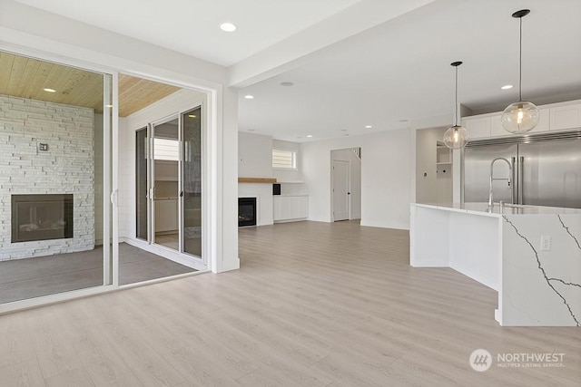 unfurnished living room featuring light wood-type flooring and a fireplace