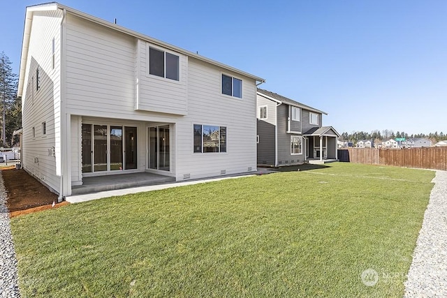 back of property with a lawn and a patio