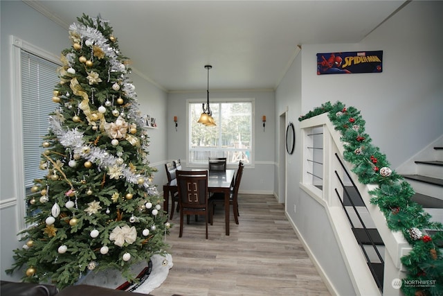 dining space with light wood-type flooring and crown molding