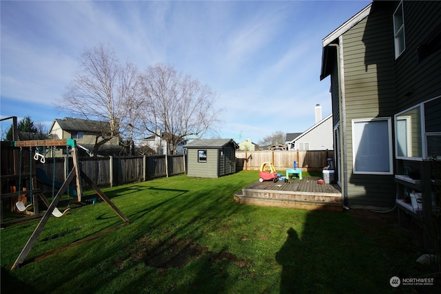 view of yard with a shed, a playground, and a deck