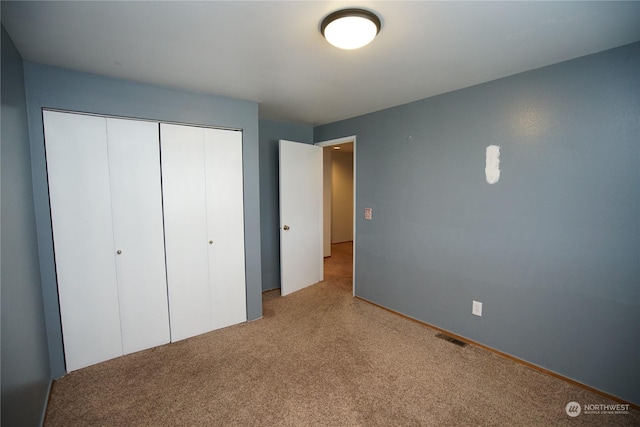 unfurnished bedroom with a closet and carpet floors