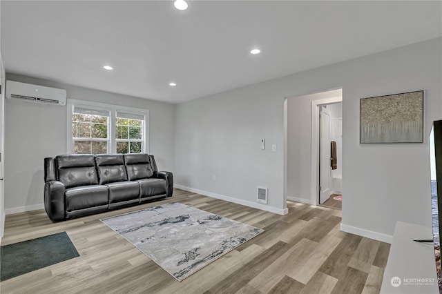 living room featuring light wood-type flooring and a wall mounted AC