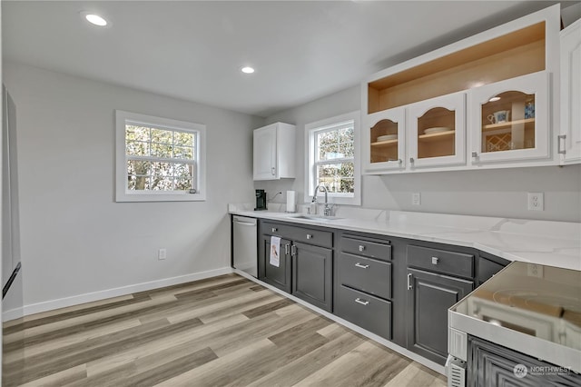 kitchen featuring light stone countertops, stainless steel dishwasher, sink, white cabinets, and gray cabinets