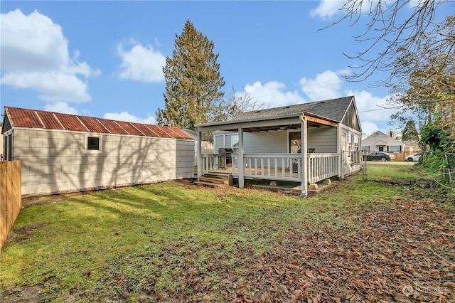 rear view of house featuring a lawn and a wooden deck