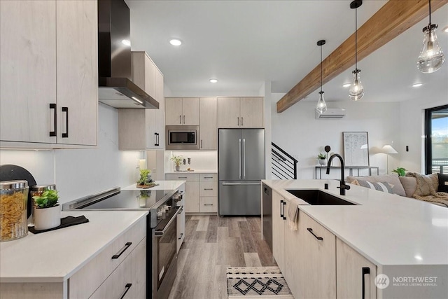 kitchen with beamed ceiling, sink, hanging light fixtures, stainless steel appliances, and wall chimney exhaust hood