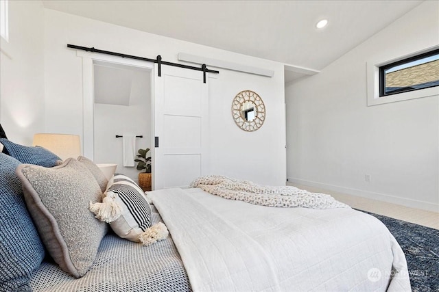 bedroom featuring lofted ceiling, a barn door, and carpet