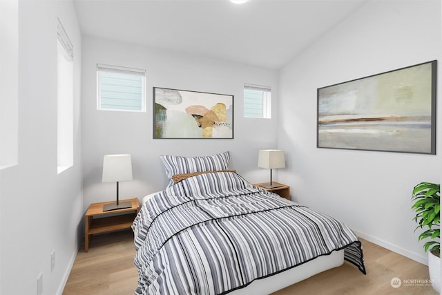 bedroom with light hardwood / wood-style flooring and lofted ceiling