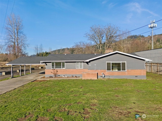 back of property featuring a carport and a yard