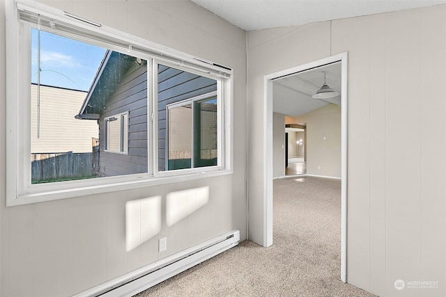 hallway with light carpet, lofted ceiling, and a baseboard heating unit