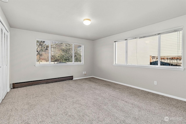 unfurnished bedroom featuring baseboard heating, a closet, and carpet floors