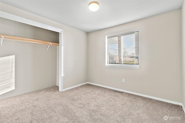 unfurnished bedroom with a closet and carpet floors