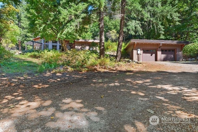 view of yard featuring a garage and an outbuilding