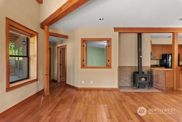 unfurnished living room with a wood stove and light hardwood / wood-style flooring