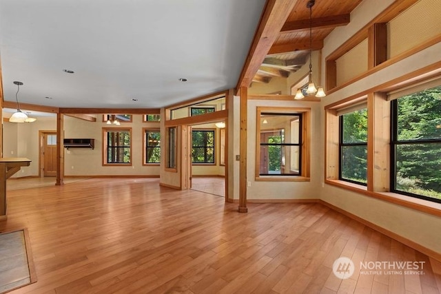 unfurnished living room featuring ceiling fan with notable chandelier and light hardwood / wood-style flooring