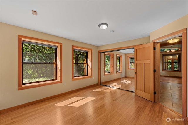 spare room with a wealth of natural light and light hardwood / wood-style floors