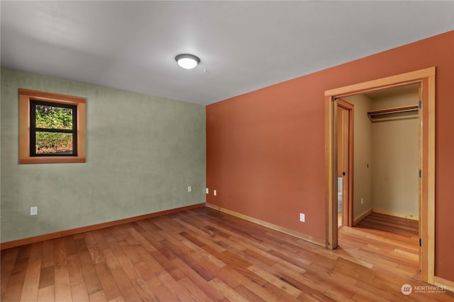 unfurnished bedroom with a closet and light hardwood / wood-style flooring