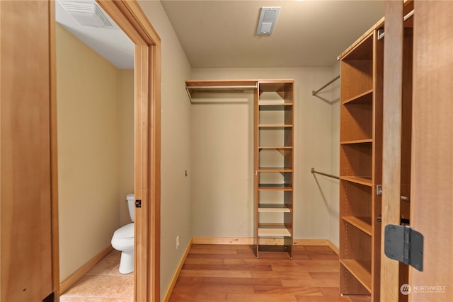 spacious closet with light hardwood / wood-style flooring