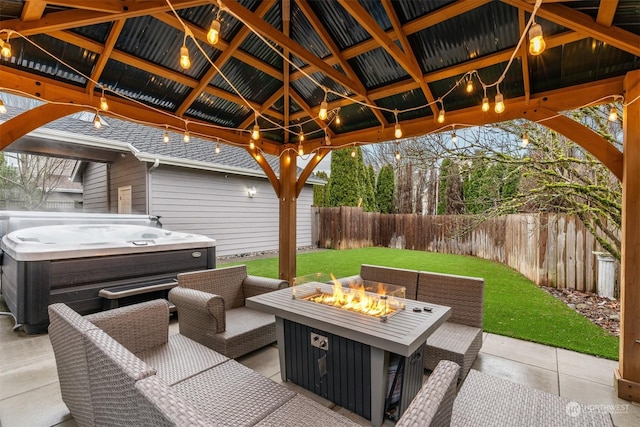 view of patio with a gazebo, a hot tub, and an outdoor fire pit