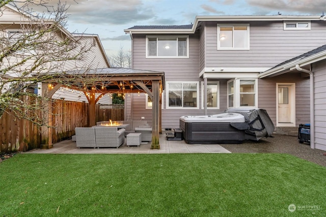 back of property with a gazebo, a hot tub, a lawn, and an outdoor living space with a fire pit