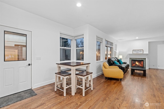 living room with a tiled fireplace and light hardwood / wood-style floors