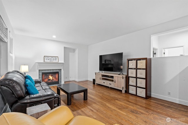 living room featuring light hardwood / wood-style floors and a tile fireplace